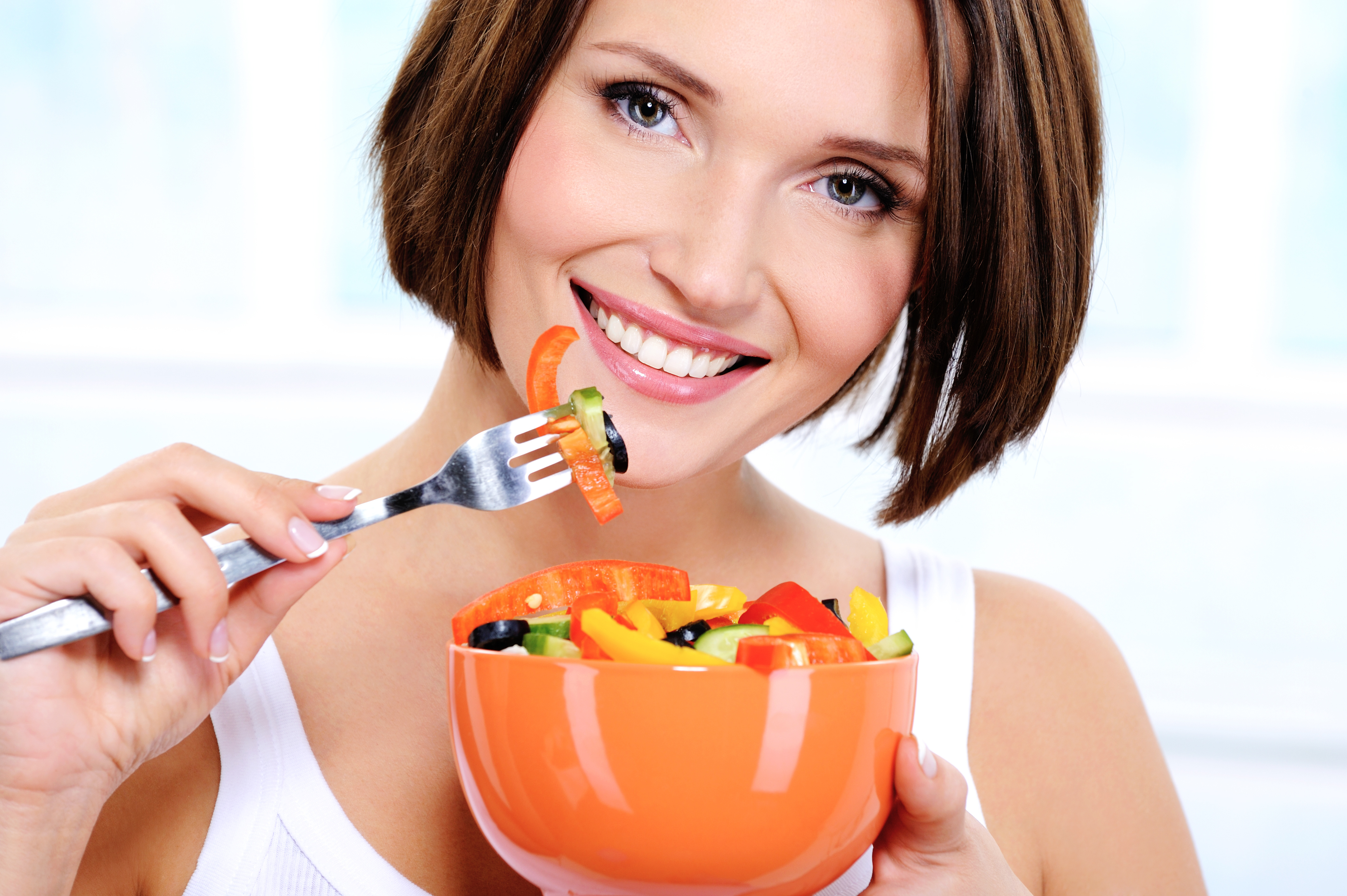 woman with a plate of vegetable salad in hands