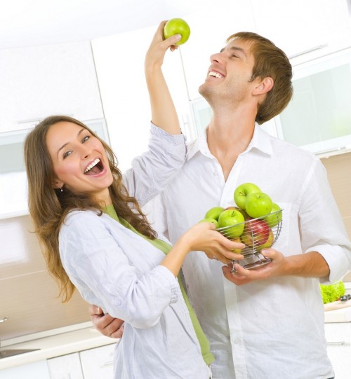 Happy Couple Eating fresh fruits.Having fun on a kitchen.Dieting
